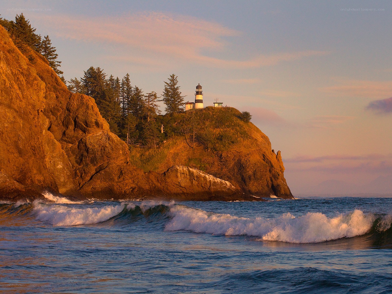 Lighthouse on coastal cliff at sunset