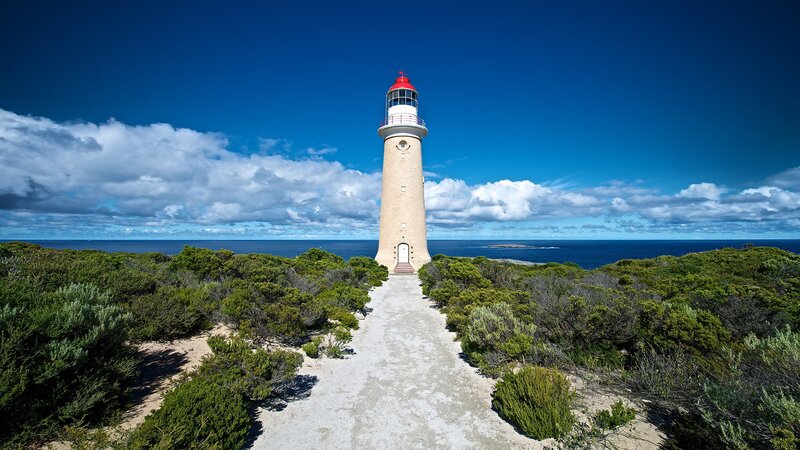 Lighthouse on Coastal Cliff — Blue, Serene, Afternoon, Photograph, Ocean, Sky