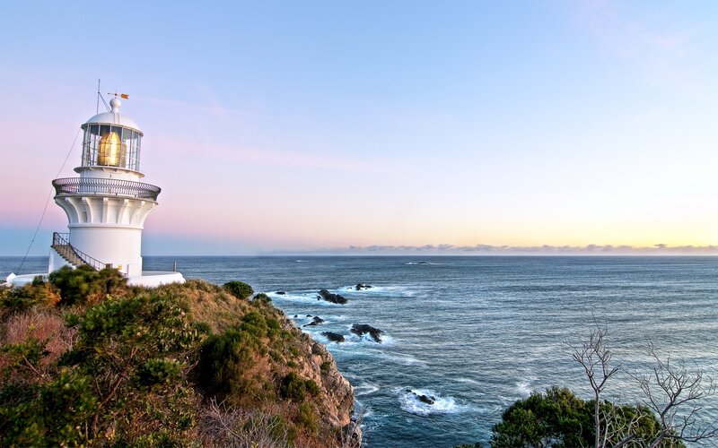 Lighthouse on Coastal Cliff — Blue, Serene, Sunset, Photograph