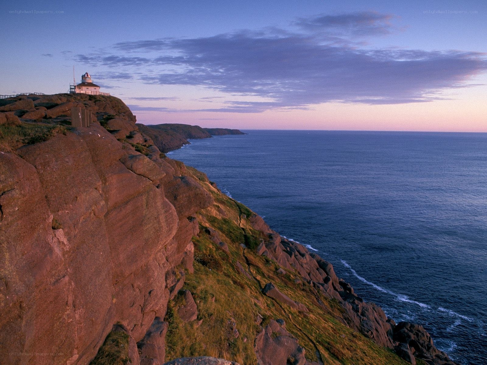 Lighthouse on coastal cliffs at dusk