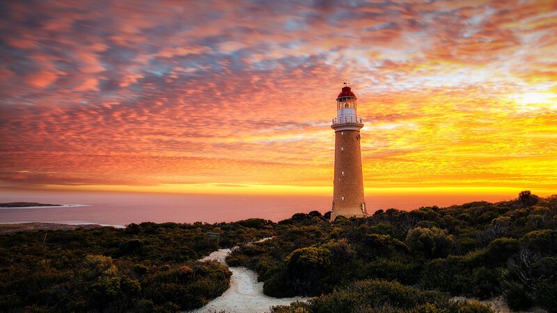 Lighthouse on Coastal Hill — Orange, Dramatic