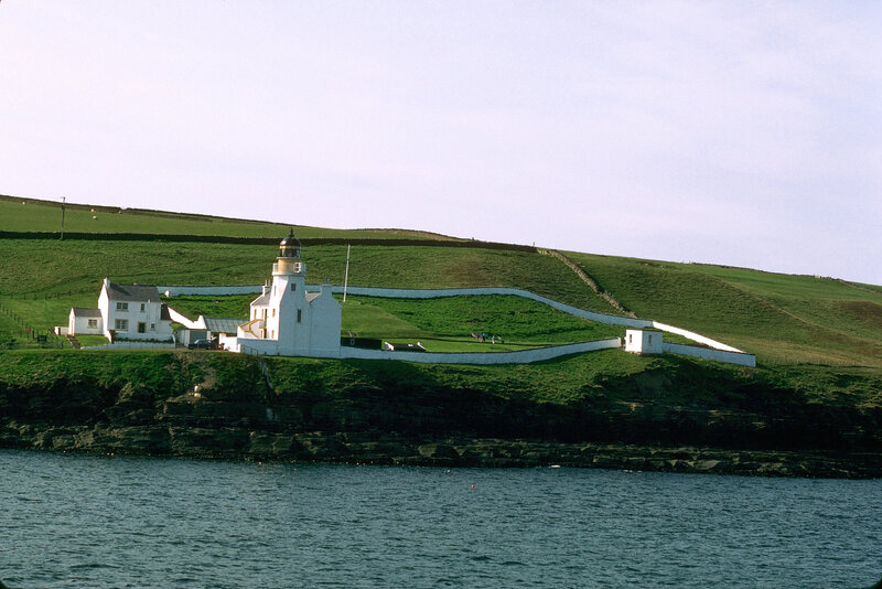 lighthouse on green hillside