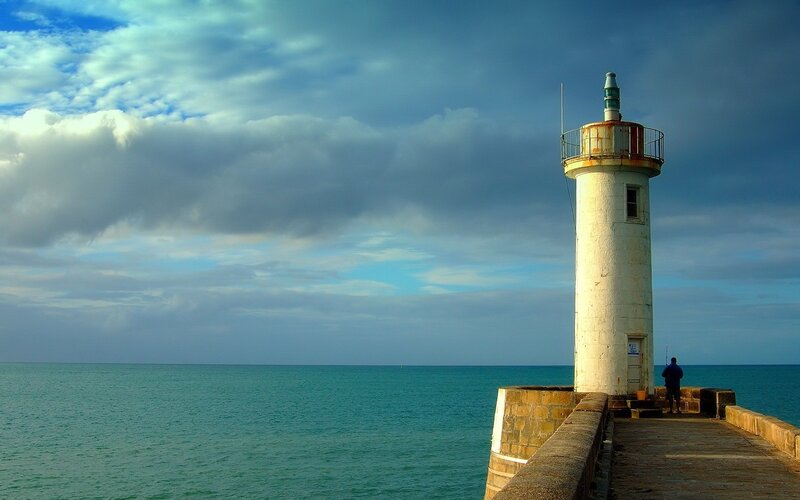 Lighthouse on Pier — Blue, Dramatic, Afternoon, Photograph, Person