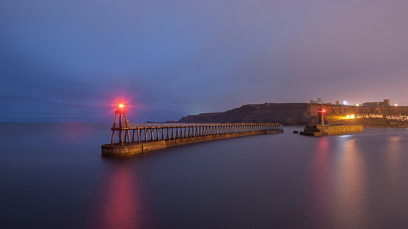 Lighthouse on Pier — Blue, Serene, Night, Photograph, Cliffs