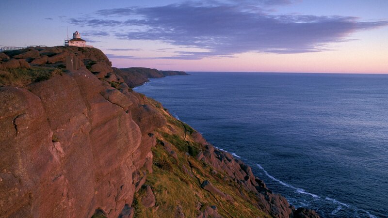 lighthouse on rocky cliff at dusk