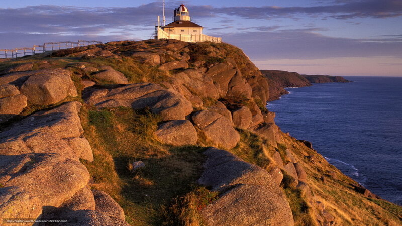 Lighthouse on rocky cliff at sunset