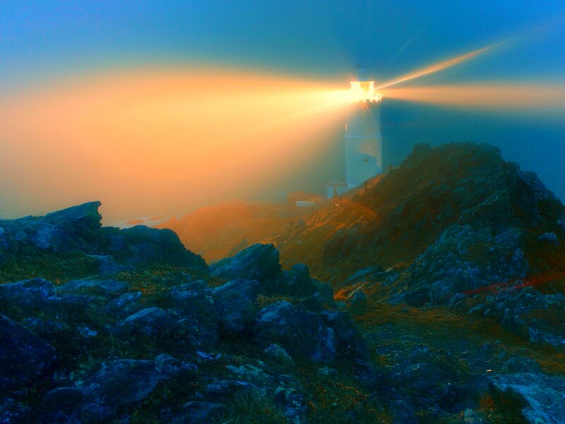 Lighthouse on Rocky Cliff — Blue, Dramatic, Sunset, Photograph, Fog