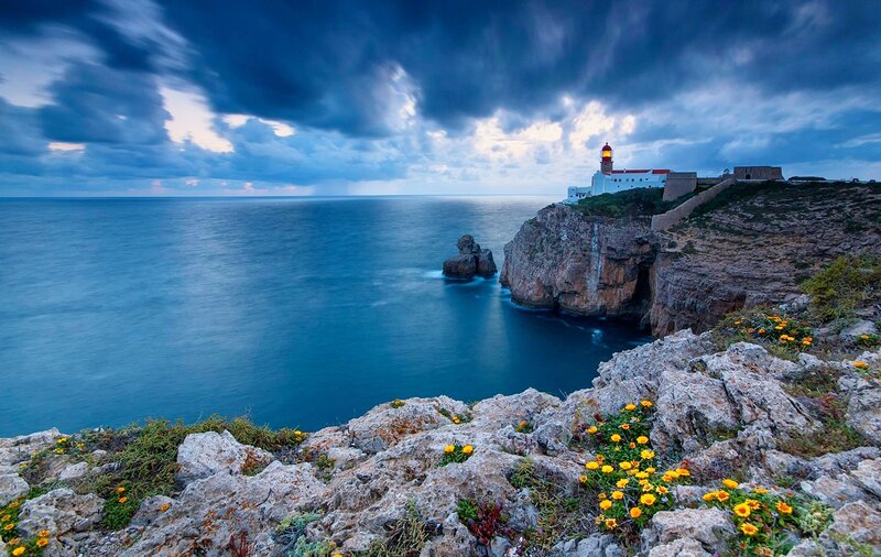 Lighthouse on Rocky Cliff — Blue, Dramatic, Sunset, Photograph, Ocean, Clouds