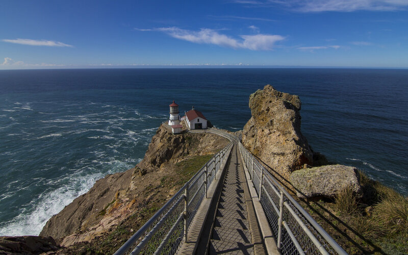 Lighthouse on Rocky Cliff — Blue, Serene, Afternoon, Photograph, Ocean, Bridge