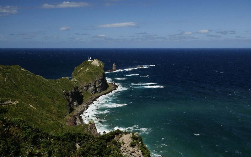 Lighthouse on Rocky Cliff — Blue, Serene, Afternoon, Photograph, Ocean, Rock Formation