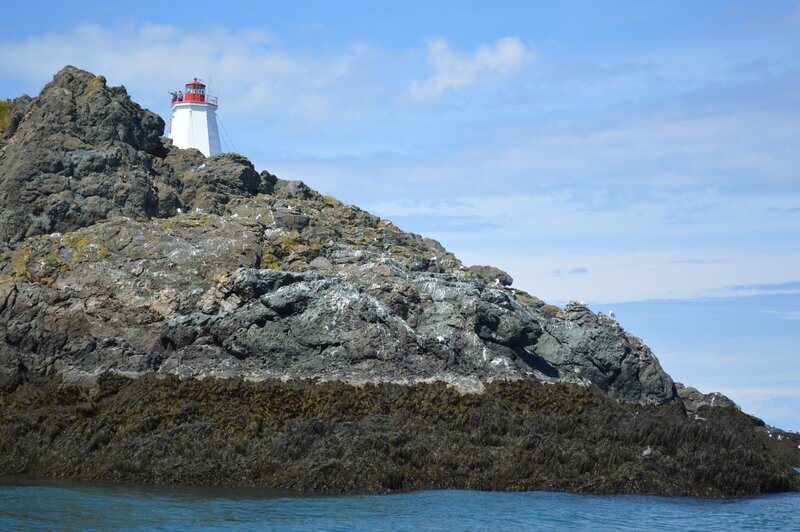 Lighthouse on Rocky Cliff — Blue, Serene, Afternoon, Photograph, Sea, Sky