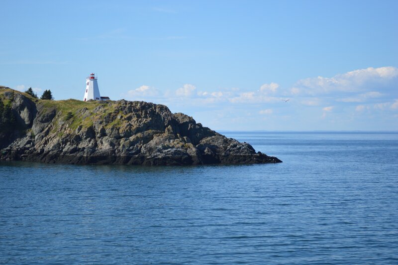 Lighthouse on Rocky Cliff — Blue, Serene, Afternoon, Photograph, Sea