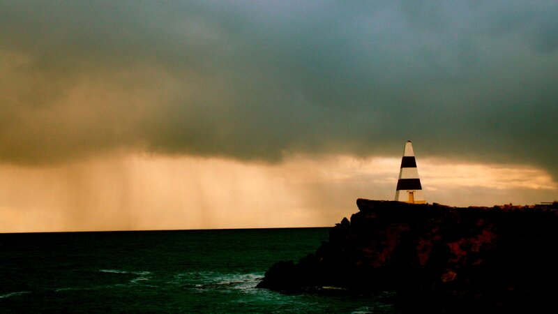 Lighthouse on Rocky Cliff — Gray, Dramatic, Sunset, Photograph, Ocean