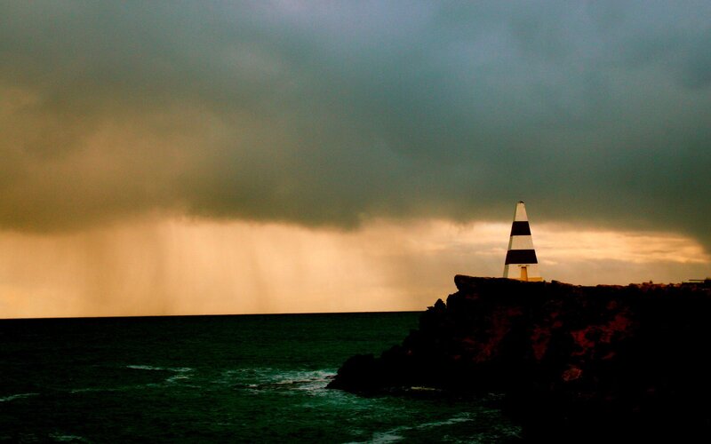 Lighthouse on Rocky Cliff — Gray, Dramatic