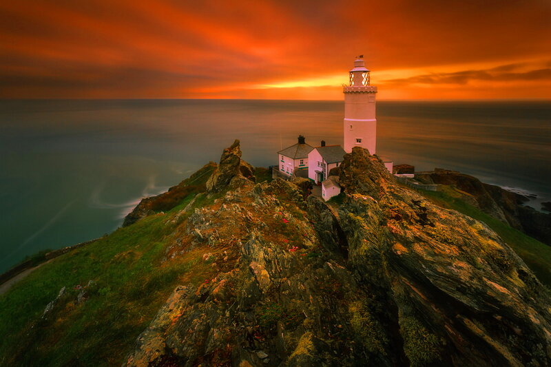 Lighthouse on Rocky Cliff — Orange, Dramatic, Sunset, Photograph, Ocean, Sky, Rocks