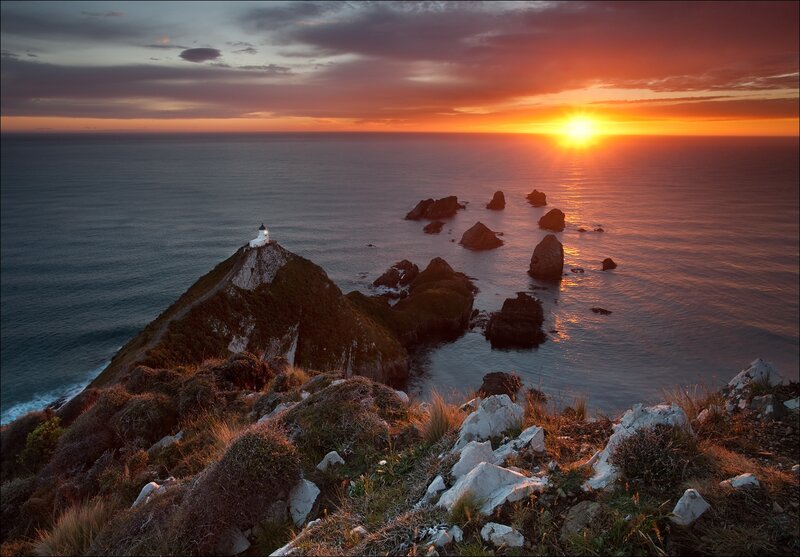 Lighthouse on Rocky Cliff — Orange, Dramatic, Sunset, Photograph, Ocean