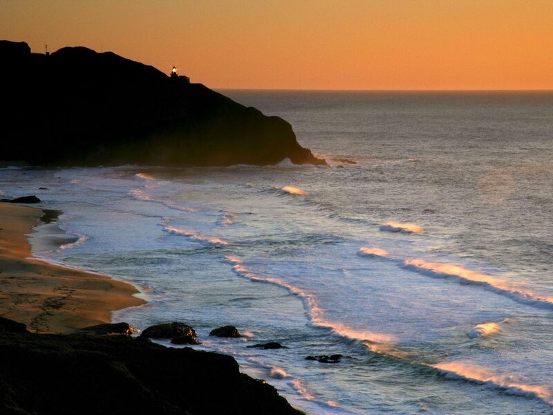 Lighthouse on Rocky Cliff — Orange, Serene, Sunset, Photograph