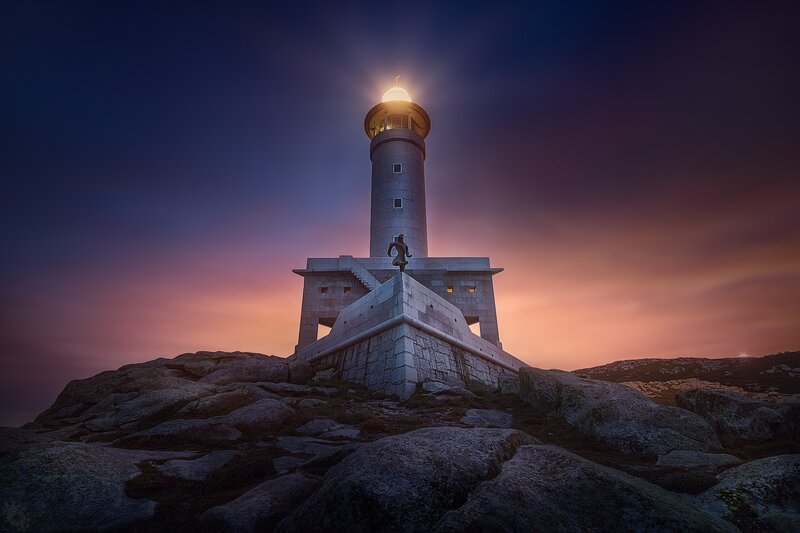 Lighthouse on Rocky Cliff — Purple, Dramatic, Sunset, Photograph, Statue