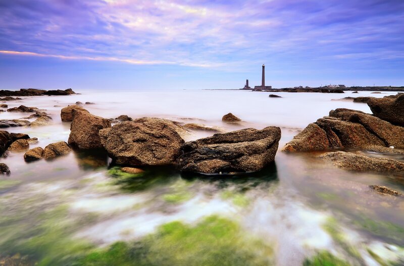 Lighthouse on rocky coast at dusk