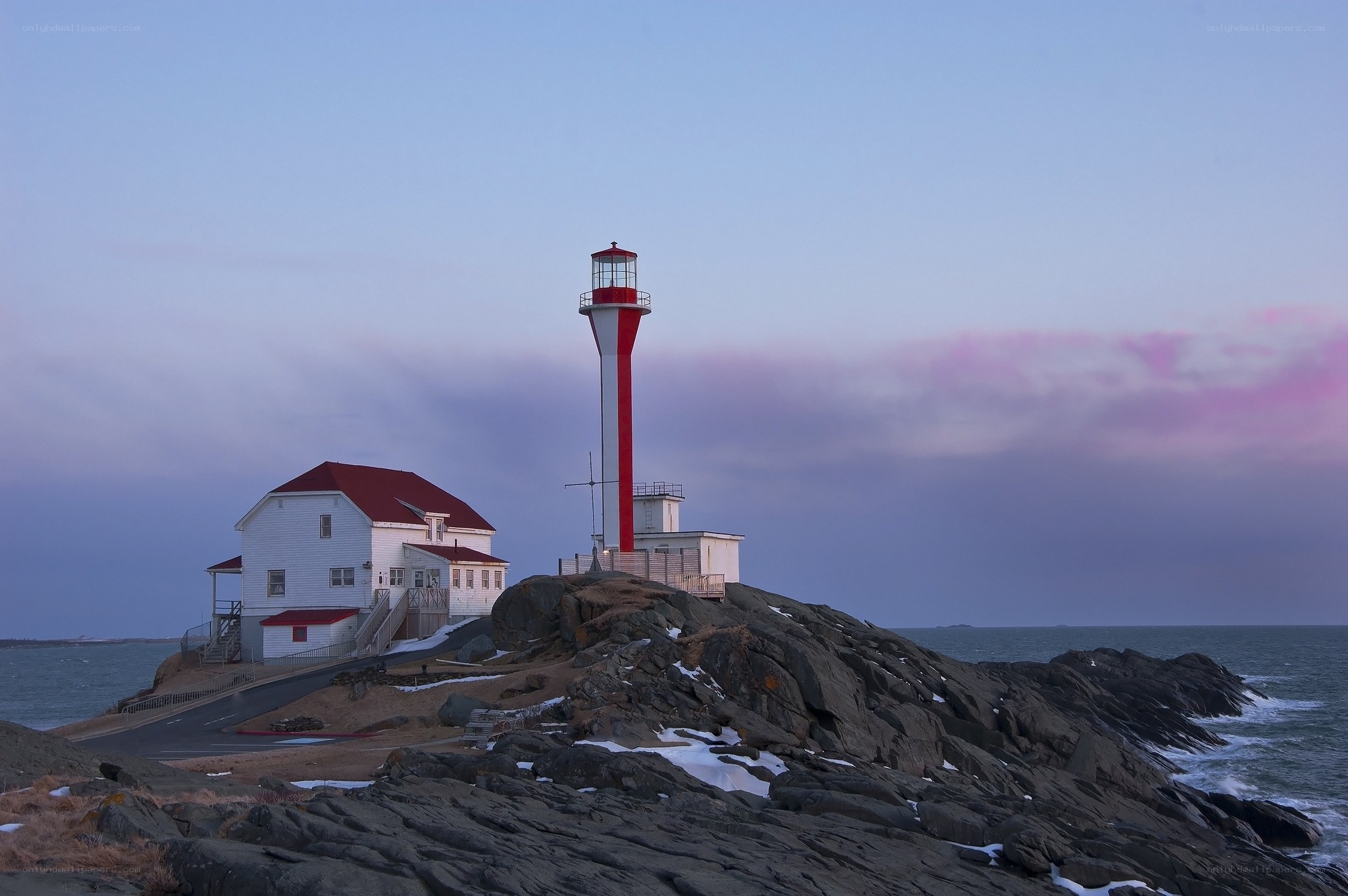 Lighthouse on rocky coast at dusk
