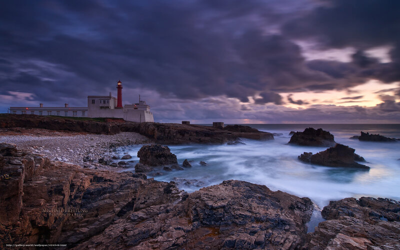 Lighthouse on rocky coast at dusk