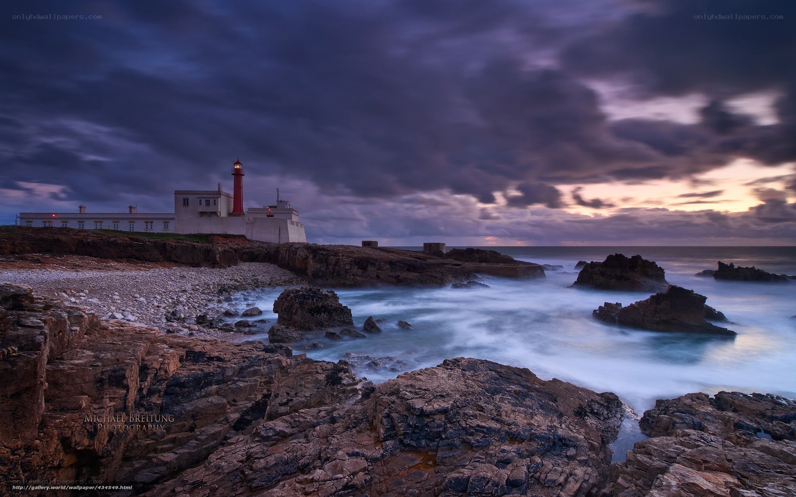 Lighthouse on rocky coast at dusk