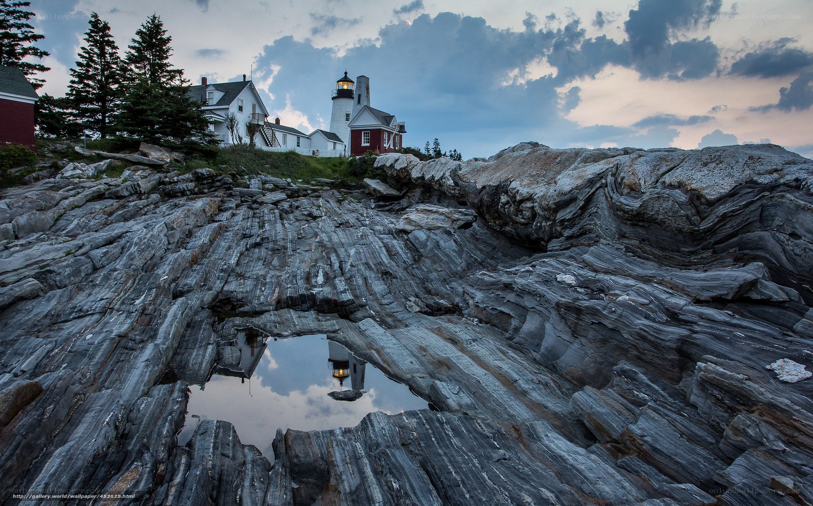 Lighthouse on rocky coast at dusk