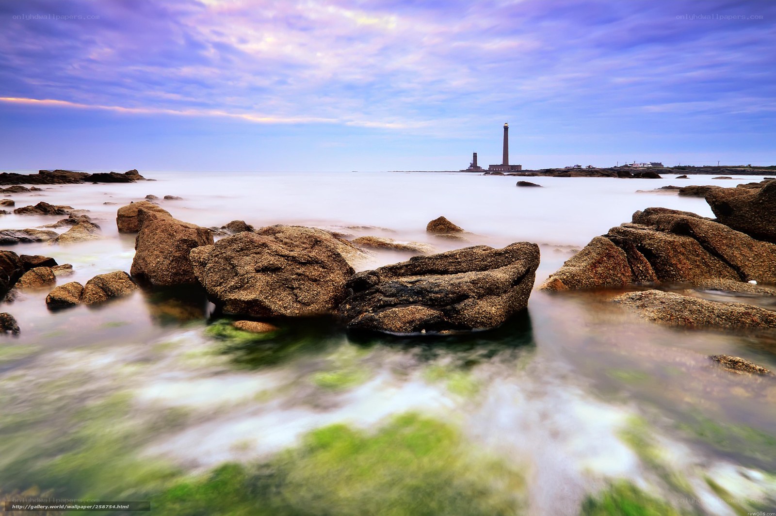 Lighthouse on rocky coast at dusk