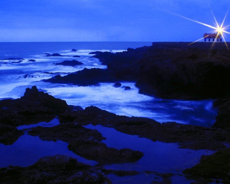 lighthouse on rocky coast at night