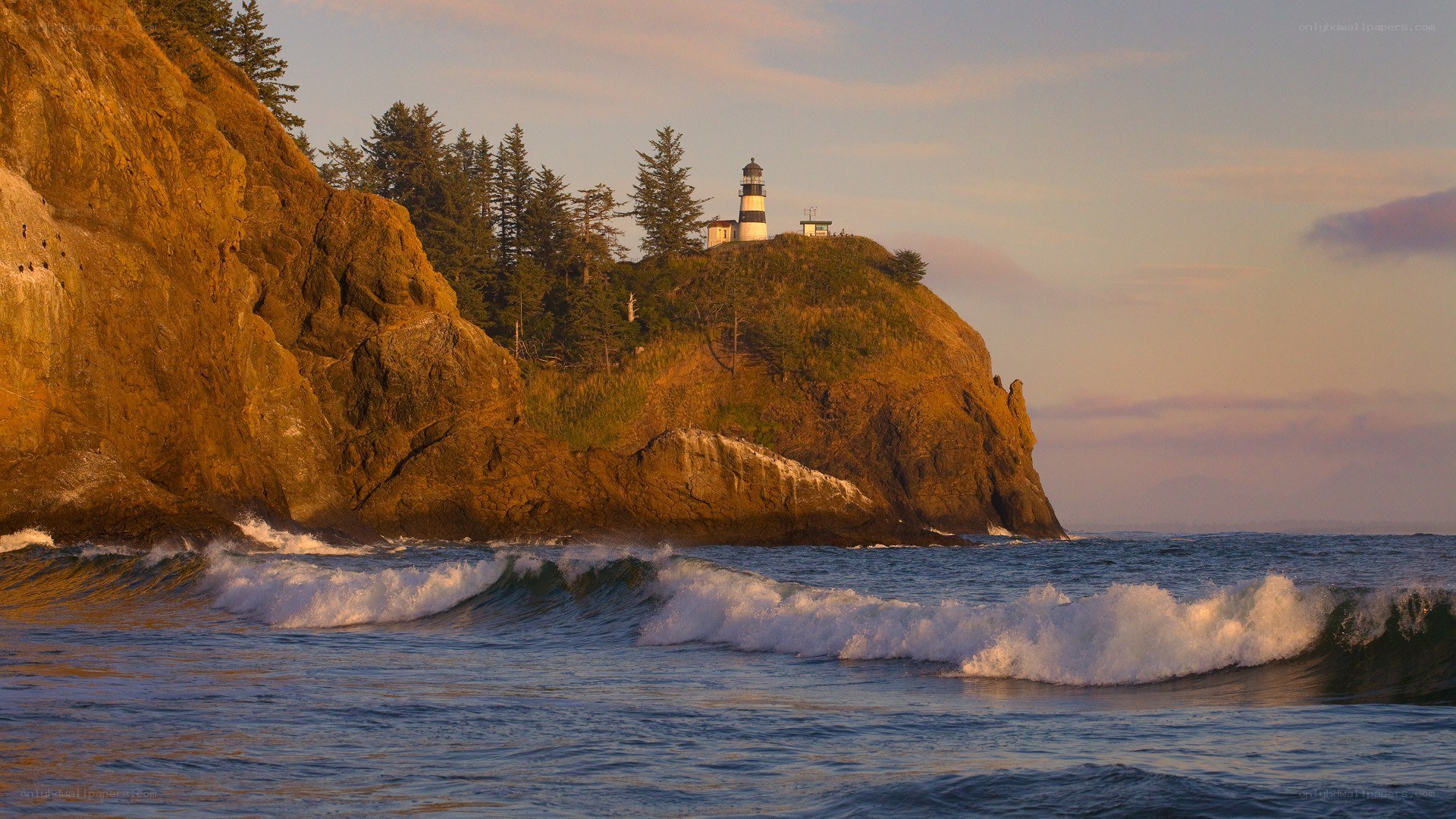 lighthouse on rocky coast at sunset