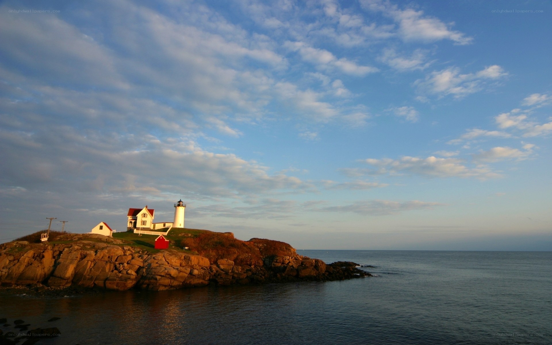 lighthouse on rocky coast at sunset