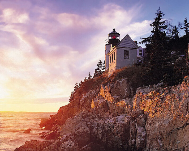 lighthouse on rocky coast at sunset