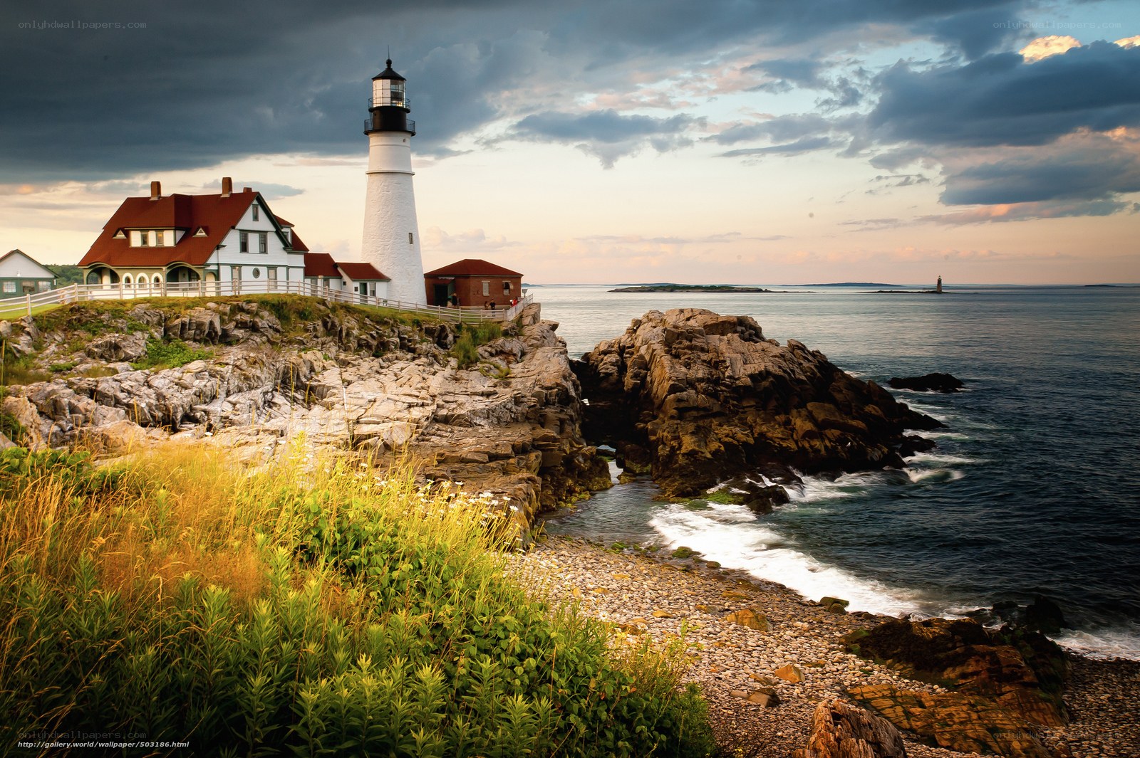 Lighthouse on rocky coast at sunset