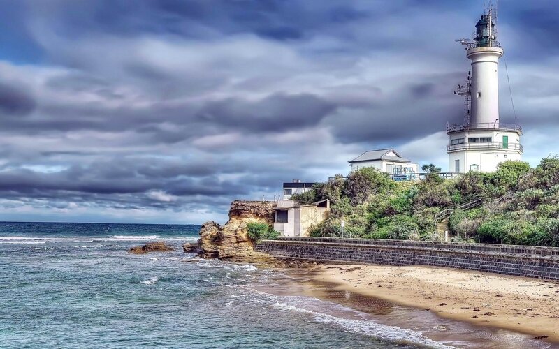 Lighthouse on Rocky Coast — Blue, Dramatic, Afternoon, Photograph, Ocean, Beach