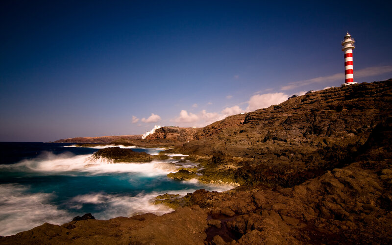 Lighthouse on Rocky Coast — Blue, Dramatic, Afternoon, Photograph, Ocean, Waves, Cliffs
