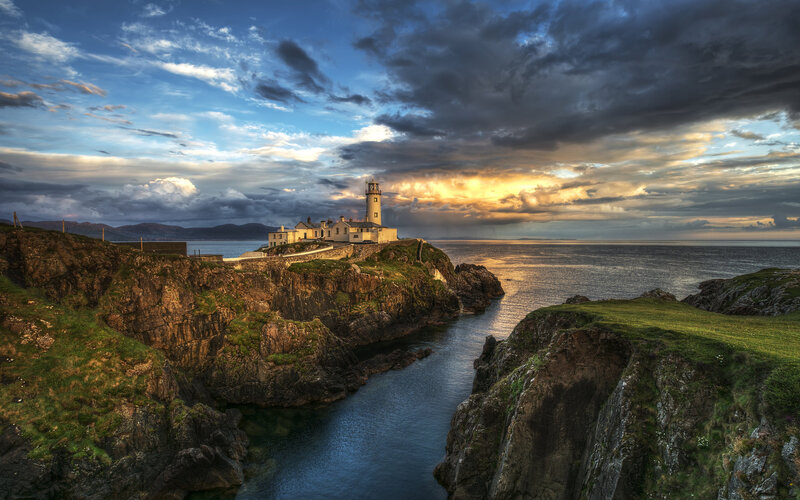 Lighthouse on Rocky Coast — Blue, Dramatic, Sunset, Photograph, Cliffs