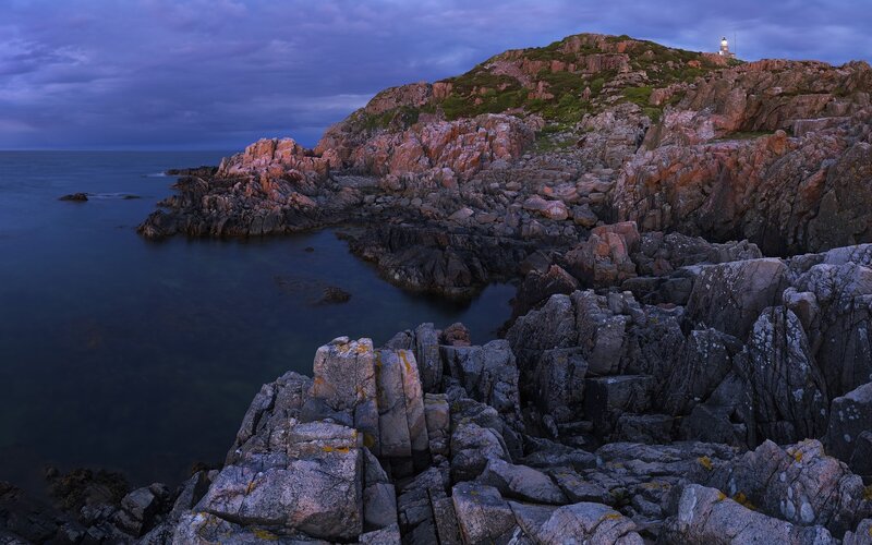 Lighthouse on Rocky Coast — Blue, Dramatic, Sunset, Photograph, Coastline