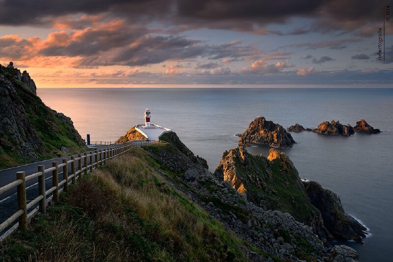 Lighthouse on Rocky Coast — Blue, Dramatic, Sunset, Photograph, Ocean, Cliffs, Road
