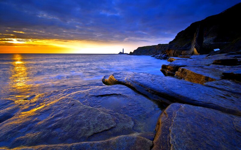 Lighthouse on Rocky Coast — Blue, Dramatic, Sunset, Photograph, Ocean, Cliffs, Sky