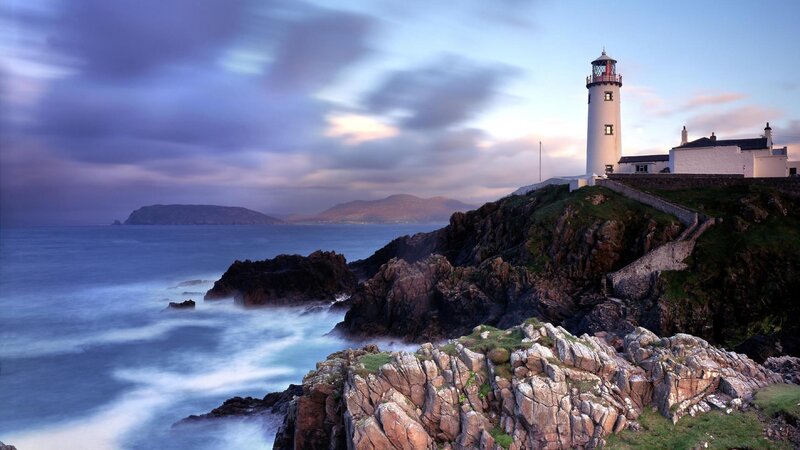 Lighthouse on Rocky Coast — Blue, Dramatic, Sunset, Photograph, Ocean, Mountains, Sky