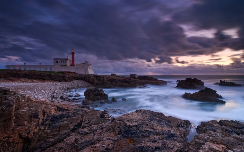 Lighthouse on Rocky Coast — Blue, Dramatic, Sunset, Photograph, Ocean, Rocks