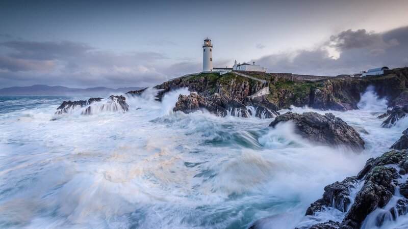 Lighthouse on Rocky Coast — Blue, Dramatic, Sunset, Photograph, Ocean Waves, Cliffs
