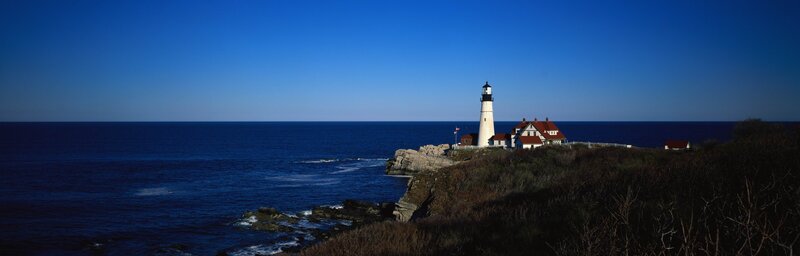 Lighthouse on Rocky Coast — Blue, Serene, Afternoon, Photograph, Ocean, Cliffs, Buildings
