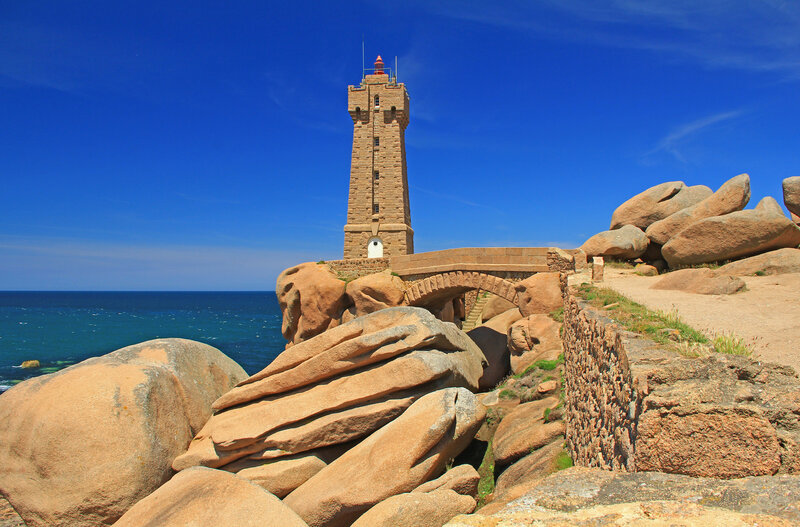 Lighthouse on Rocky Coast — Blue, Serene, Afternoon, Photograph, Ocean, Rocks, Bridge