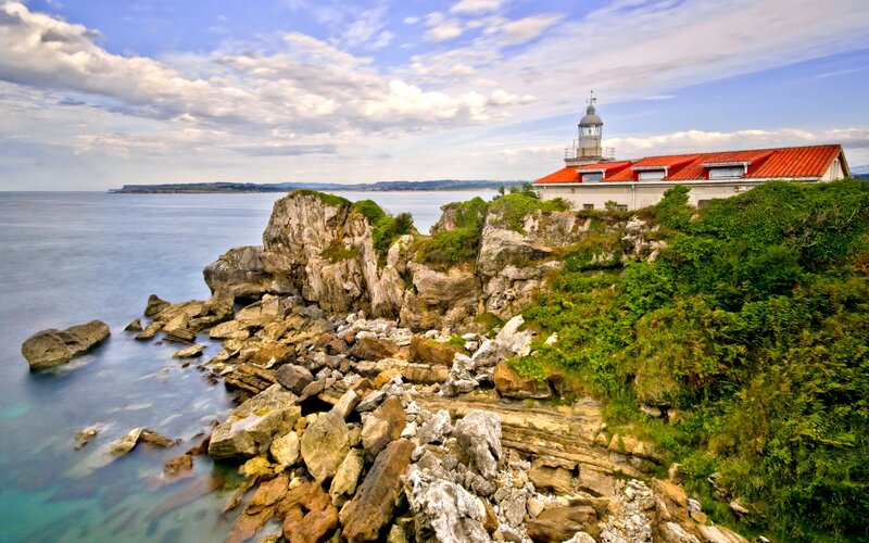 Lighthouse on Rocky Coast — Blue, Serene, Afternoon, Photograph, Ocean, Rocks, Clouds