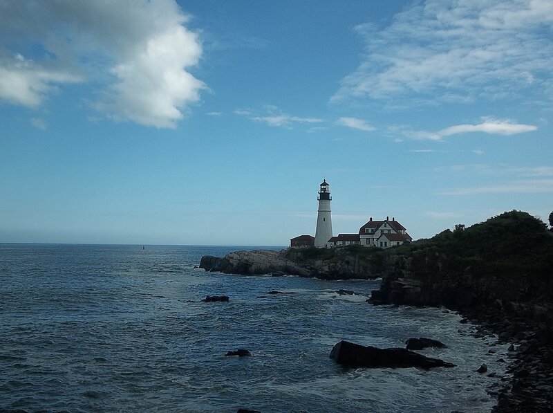 Lighthouse on Rocky Coast — Blue, Serene, Afternoon, Photograph, Ocean, Rocks, Sky