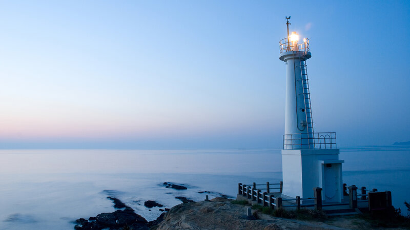 Lighthouse on Rocky Coast — Blue, Serene, Dusk
