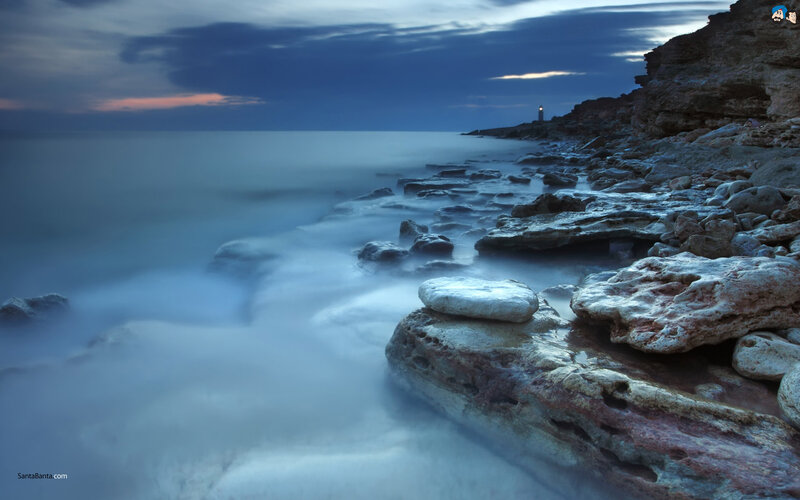 Lighthouse on Rocky Coast — Blue, Serene, Night, Photograph, Rocks, Ocean, Sky