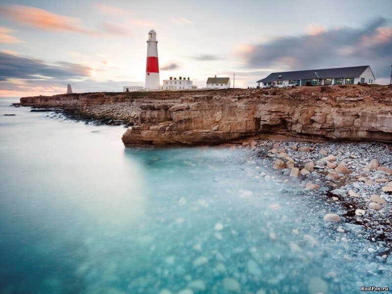 Lighthouse on Rocky Coast — Blue, Serene, Sunset, Photograph, Cliffs