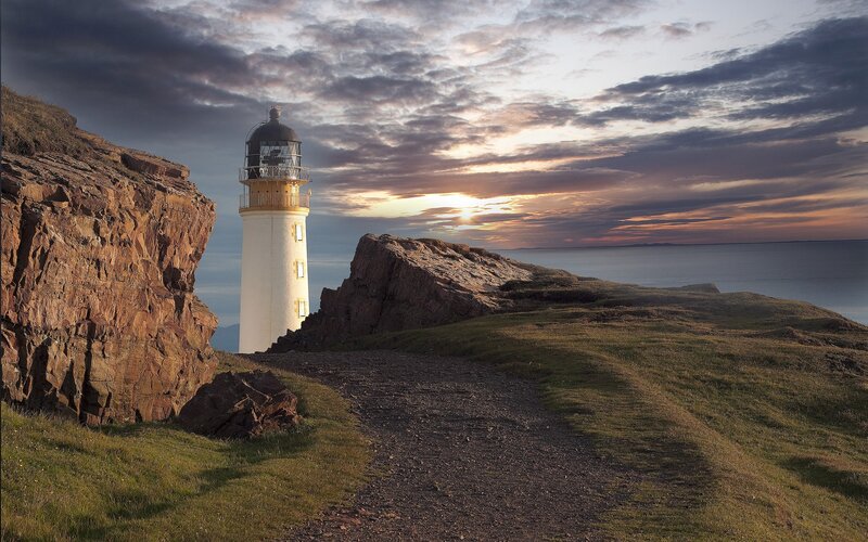 Lighthouse on Rocky Coast — Brown, Dramatic, Sunset, Photograph
